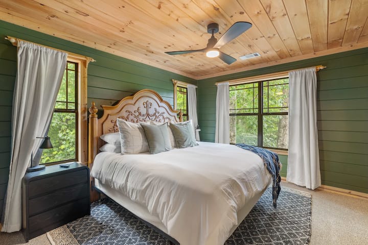 A beautifully styled King bedroom with forest views and warm natural light.