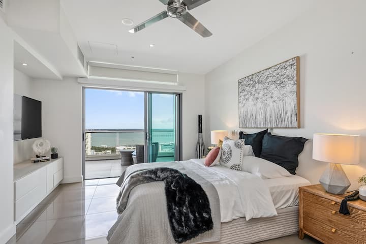 Master bedroom with King bed, glass doors out onto balcony and TV.