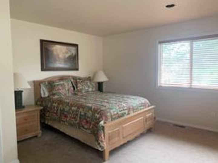 Dormitorio con cama tamaño queen y baño compartido