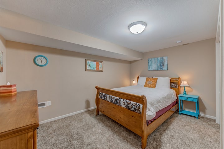 A large queen bed and teal accents make this room both fun and comfortable for your stay.