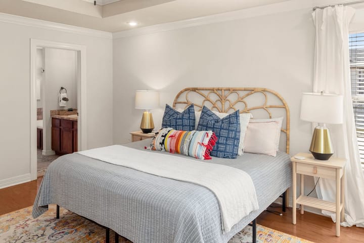 Dormitorio principal: relájate en una suite con cama tamaño king con sábanas de lujo, cortinas y una decoración relajante.