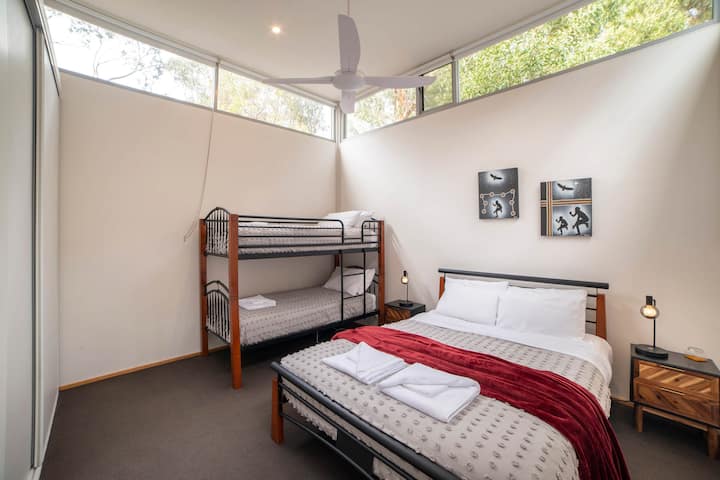 חדר שינה 2: מיטת קווין סייז ומיטות קומתיים לסידורי שינה מגוונים.