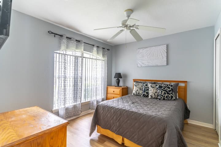 Dormitorio delantero tamaño queen con TV de pantalla plana, suelo recién instalado, paredes recién pintadas y ropa de cama nueva.