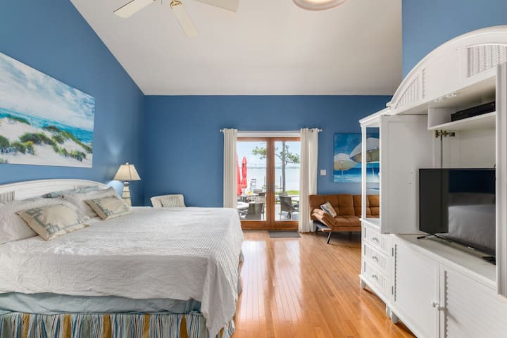 Chumba cha Kulala cha Msingi chenye Kitanda cha King na Futoni. Mwonekano wako wa maji wa faragha