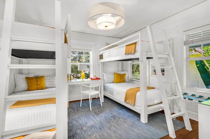 Dhomë gjumi e ndriçuar dhe e ajrosur me krevate marinari, me dy krevate të rinj marinari të qëndrueshëm XL, vepra arti moderne dhe një tavolinë personale me karrige, ideale për punë në distancë. Shijo një televizor inteligjent dhe pamje të qeta me pamje nga rruga e qetë Flamingo Park.