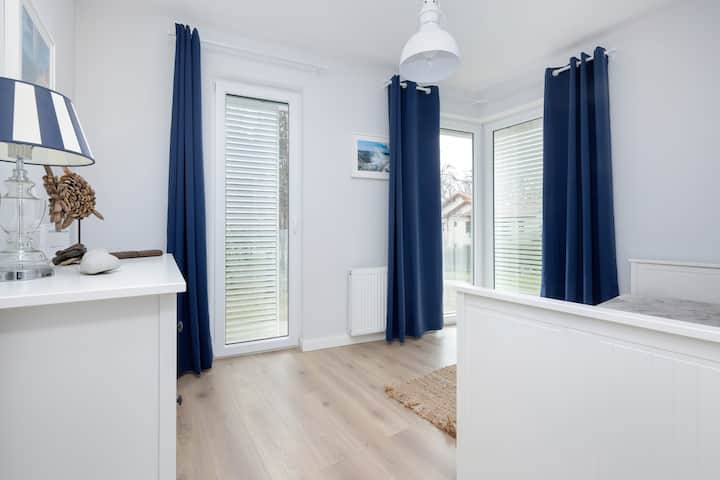 : კიდევ ერთი ხედი საძინებელზე თეთრი ავეჯითა და მინიმალისტური დეკორით.