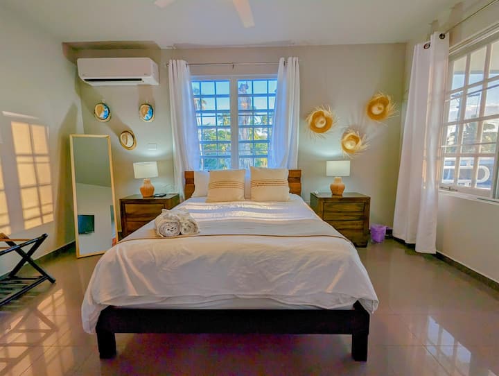 Master Bedroom: Sunlit sanctuary with a balcony, modern decor, and serene palm views!