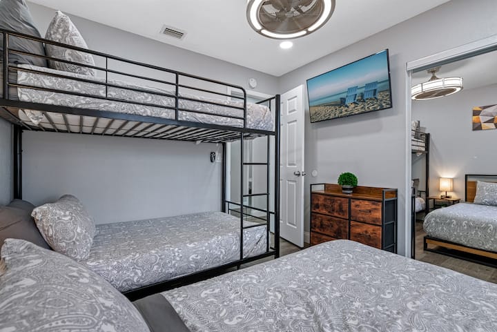 Красива спалня с единично двуетажно легло, двойно легло, чекмеджета за съхранение и смарт телевизор. Идеална стая за семейство с деца или група приятели.