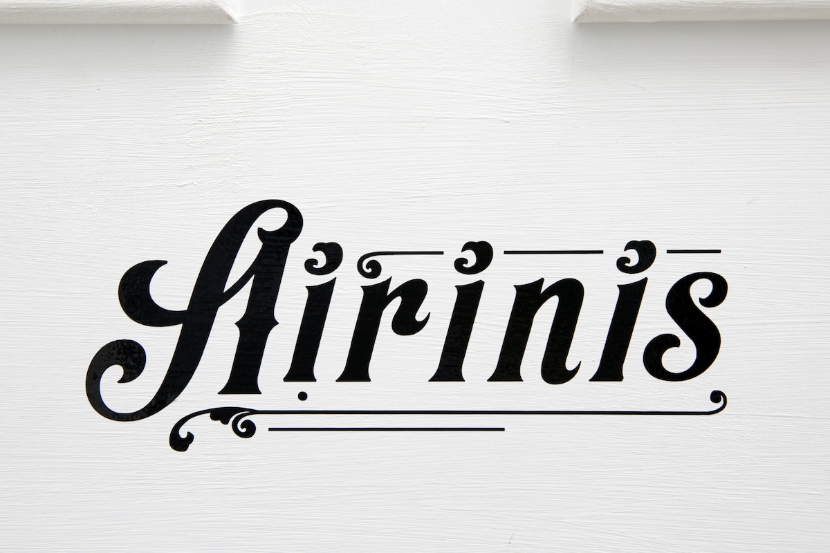 The name 'Airinis' is elegantly displayed in a stylish font on a white background, drawing attention to the apartment's identity.