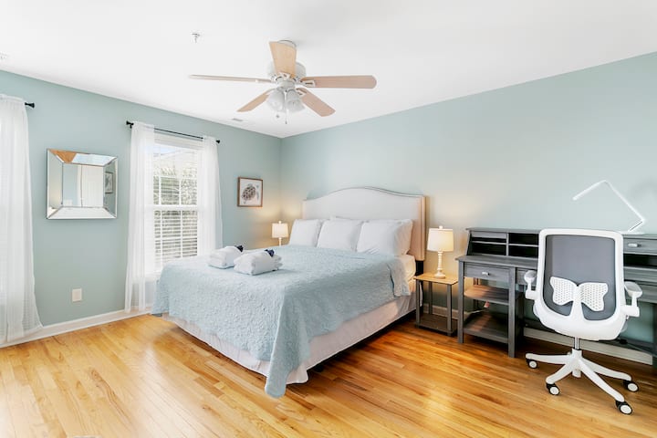 Guest bedroom upstairs featuring a king-size bed, workstation, and a Smart TV