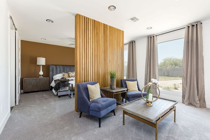 主卧配有加大双人床（带休息室座椅）、智能平板电视和独立卫生间。