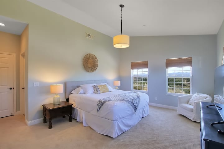 Priestranná hlavná spálňa s manželskou posteľou King a inteligentným televízorom s veľkou obrazovkou.