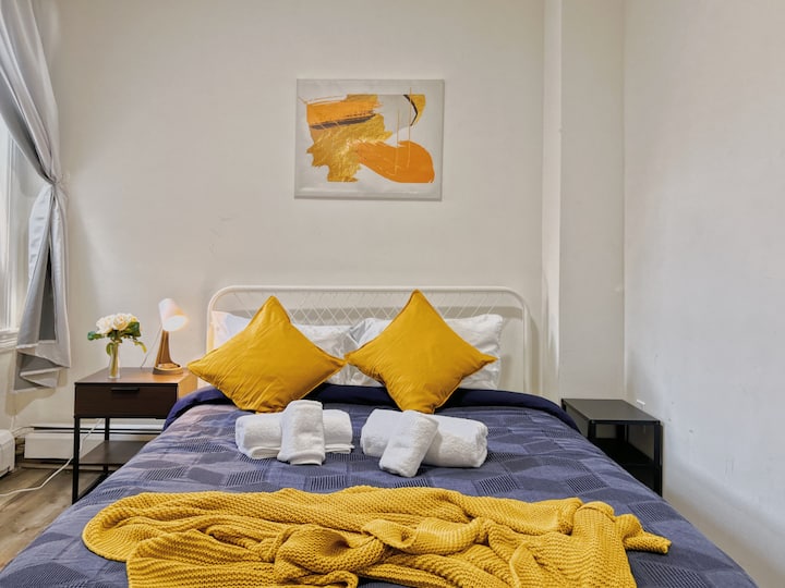 Cama tamaño queen dentro del dormitorio con sábanas limpias y almohadas esponjosas