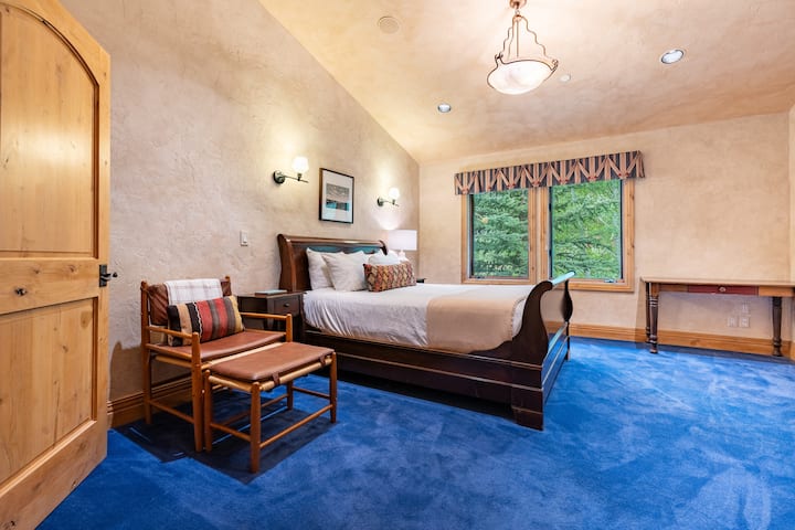 Slaapkamer 5 heeft een queensize bed, tv en een eigen badkamer.