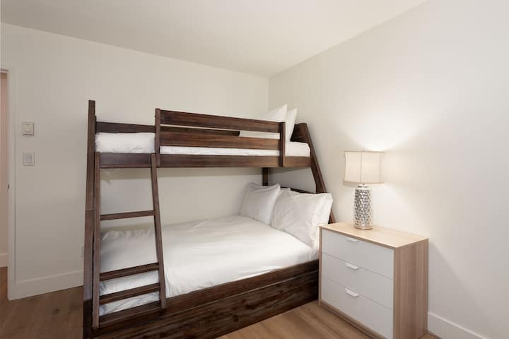 - Bedroom with twin-over-double bunk perfect for families and groups  
- Cozy bedding and soft lighting for restful alpine nights  
- Modern wood frame adds warmth and mountain-inspired comfort  
