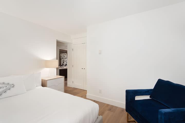 - Bedroom with plush bedding and stylish navy chair for cozy comfort  
- Bright minimalist design with calming tones for restful nights  
- Peaceful space ideal for unwinding after mountain adventures  
