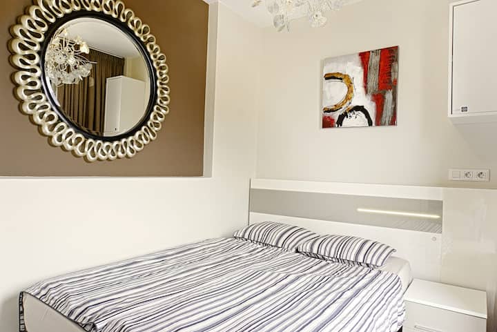 Sunny second bedroom with queen-size bed, compact yet comfortable, with direct balcony access.