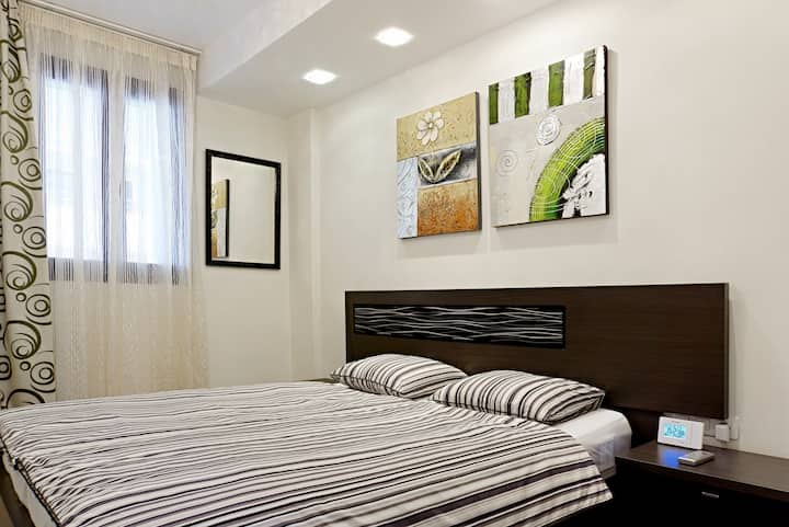 Spacious master bedroom with king-size bed, luxury mattress, and blackout curtains for restful nights.