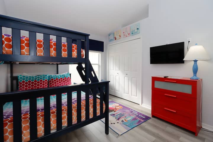 靠近迪士尼奥兰多的趣味基西米双层客房，配备彩色床上用品、冰雪奇缘主题地毯和壁挂电视。