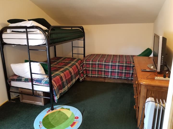 חדר שינה שלישי למעלה עם מיטת קומתיים וחדר אמבטיה זוגי עם שירותים צמודים.