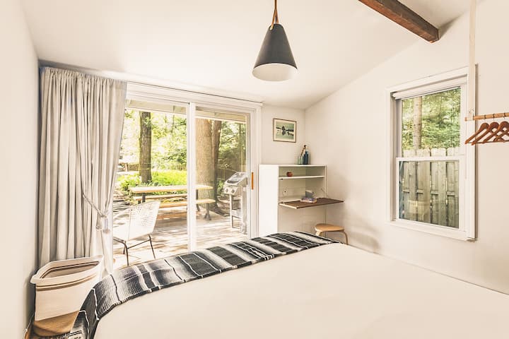 Downstairs bedroom with queen-size bed and workspace