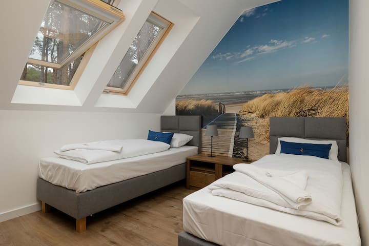 חדר שינה עם שתי מיטות יחיד נוחות.