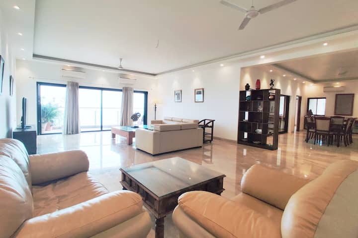 Immerse yourself in elegance with a living room featuring plush furnishings and a private balcony that captures sweeping views of the sea.