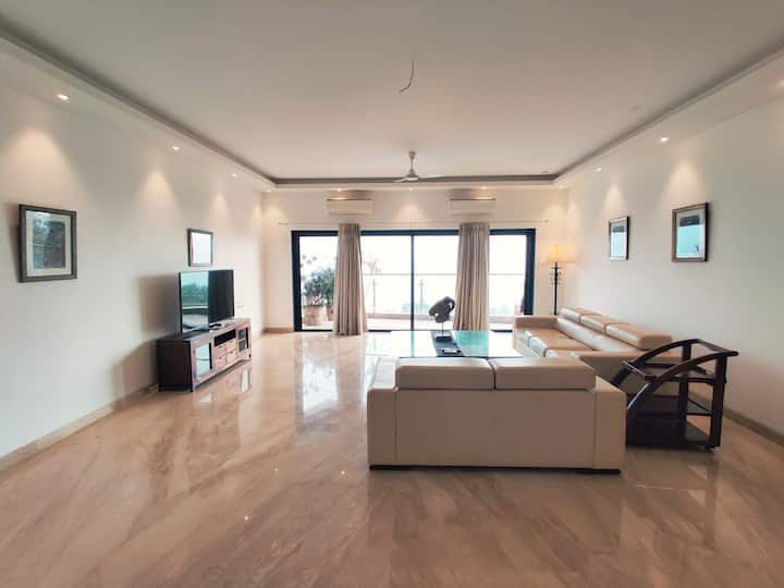 Relax in a tastefully designed living room with luxurious furnishings, leading to a private balcony that boasts stunning views of the sea.