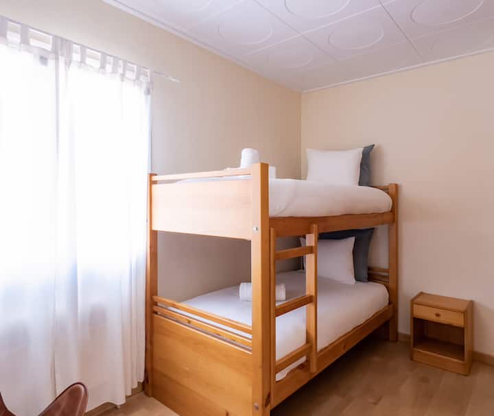 Una habitación luminosa y acogedora con literas en Sports Villa Banyoles, perfecta para familias y grupos. Disfruta de una estancia cómoda cerca de la piscina privada y el gimnasio.