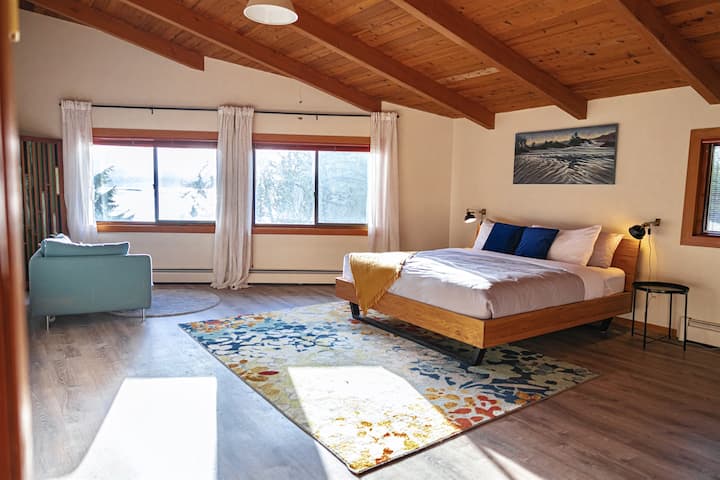 Chambre principale ensoleillée avec vue sur l'eau