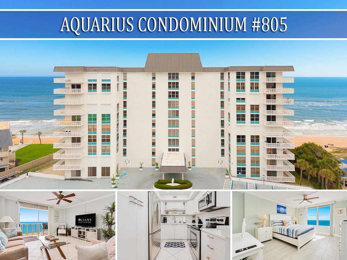 The exterior view of Aquarius Condominium showcases a modern building with multiple balconies overlooking the ocean. The beachfront property stands against a clear blue sky and the Atlantic Ocean, providing a glimpse of the surrounding serene environment.