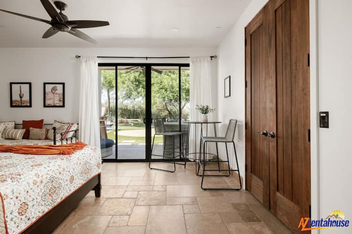 अपने स्टाइलिश बेडरूम में आराम फ़रमाए, जहाँ से आप सीधे हरे-भरे बगीचों वाले आँगन में जा सकते हैं और साथ ही सुकून भरी सुबह बिताने के लिए एक आरामदायक काम करने की जगह भी है।