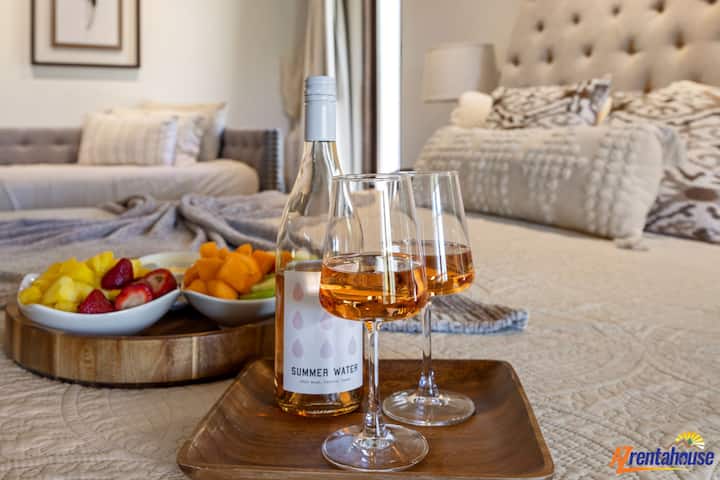 अपने खूबसूरती से सजे बेडरूम में वाइन और ताज़े फलों के साथ आराम फ़रमाएँ, जहाँ लग्ज़री और आराम का सुंदर मेल है, जिससे आप पूरी तरह से सुकून महसूस कर सकते हैं।