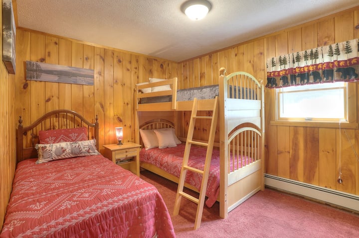 غرفة نوم في الطابق الرئيسي مع سرير بطابقين وسرير مزدوج