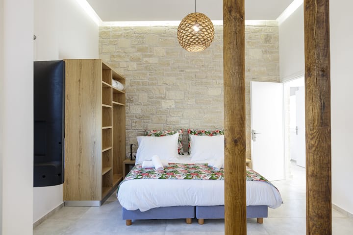 חדר זוגי עם שתי מיטות יחיד ומותקן בו מיזוג אוויר.