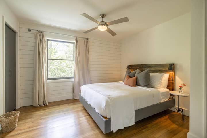 The fourth bedroom with queen bed and forest views