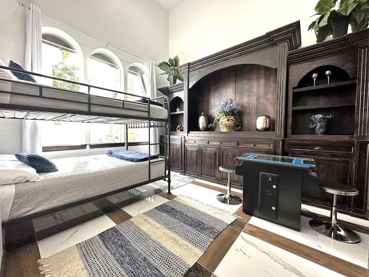 Spálňa v poschodovej izbe s 2 veľkými matracami a koktejlovou herňou.