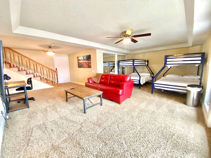 Veľká suterénna izba vybavená dvoma oddelenými posteľami nad poschodovými posteľami a rozkladacím gaučom na spanie.