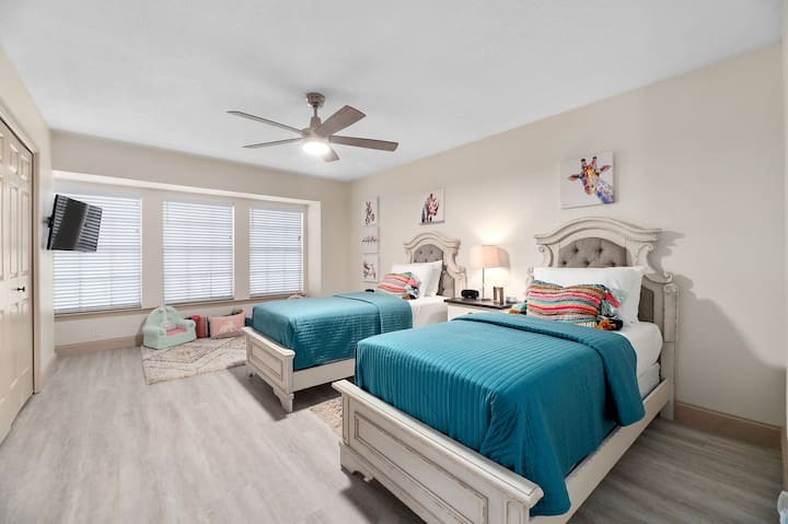 Habitación doble luminosa con obras de arte divertidas, ropa de cama acogedora y luz suave, perfecta para mañanas relajadas en Good Vibes Roll.