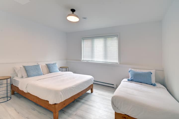 غرفة نوم بسيطة تتميز بسرير كوين وسرير مفرد - مثالية للمرونة والراحة أثناء إقامتك.