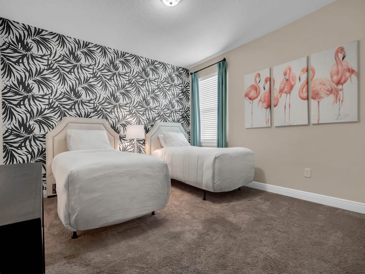 - Bedroom with twin beds and bold accent wall for unique vacation stays  
- Flamingo artwork adds colorful fun for kids and family groups  
- Perfect retreat for guests during Orlando family rental vacations