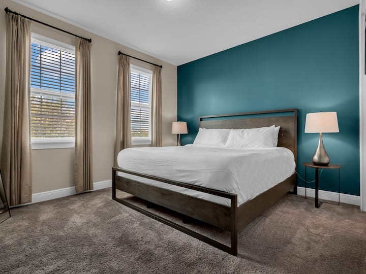 - Master bedroom with teal accent wall and king bed for family comfort  
- Spacious layout ideal for couples or parents during group stays  
- Bright natural light creates a relaxing vacation rental retreat