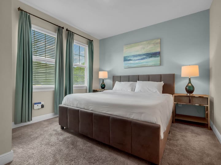 - Guest bedroom with king bed and teal accent wall for relaxing stays  
- Modern decor with artwork and natural light for comfort and style  
- Ideal for family vacations or group rental stays near Orlando