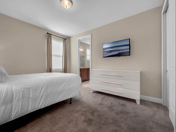 - Guest bedroom with TV, dresser and ensuite bathroom for convenience  
- Comfortable bedding and bright decor ideal for family vacations  
- Perfect for group rentals with privacy and modern features