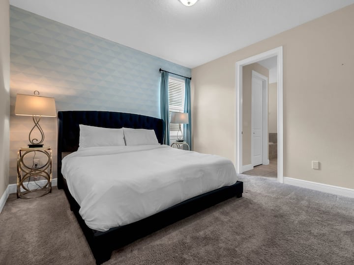 - Bedroom with patterned accent wall and king bed for cozy vacation stays  
- Spacious layout includes private access to en-suite bathroom  
- Great retreat for couples or parents during family rental trips