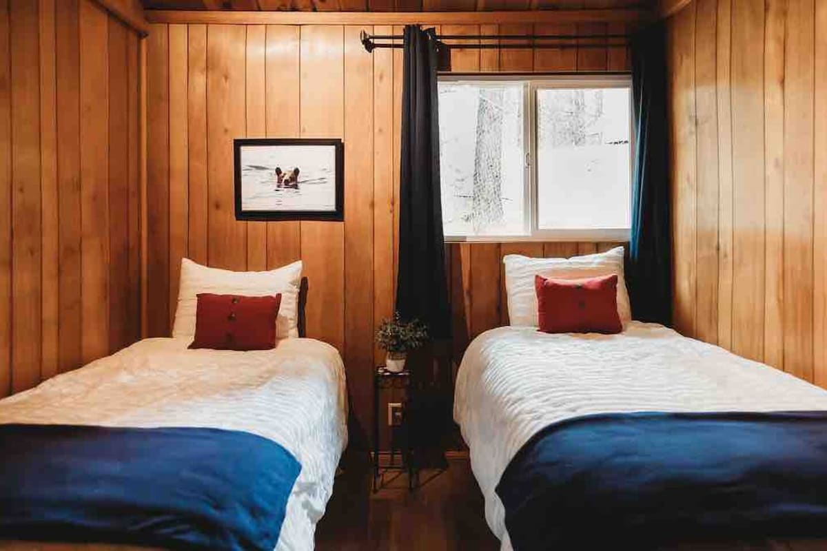 Twin beds, with sliding door closet equipped with hangers, iron board & iron, two portable heaters, folding chairs, dining table leaf extender, and baby high chair.