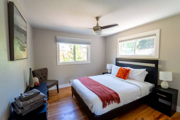 Chumba cha pili kina kitanda chenye starehe cha Queen, kabati na madirisha.