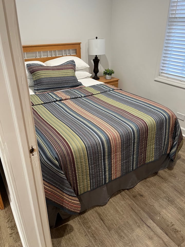 ห้องนอนสบายๆ พร้อมเครื่องนอนหลากสี พื้นไม้ และแสงนุ่มๆ