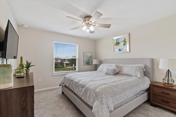 брачна спална соба со телевизор и вентилатор 