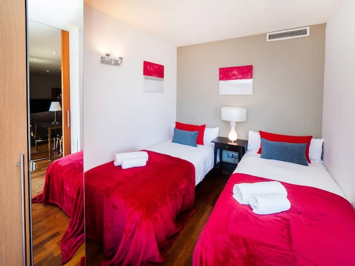 Dormitorio 4: este luminoso dormitorio en la planta principal cuenta con un armario y ventanales de suelo a techo con acceso al balcón, que ofrecen unas vistas impresionantes y mucha luz natural para una estancia cómoda.